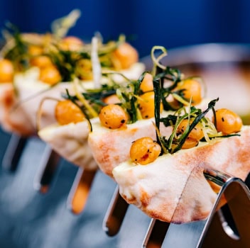 A close-up of a fork holding a variety of colorful food items, showcasing their textures and vibrant colors.