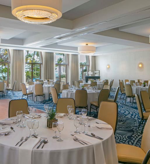 A beautifully arranged banquet room with tables and chairs set for a wedding celebration