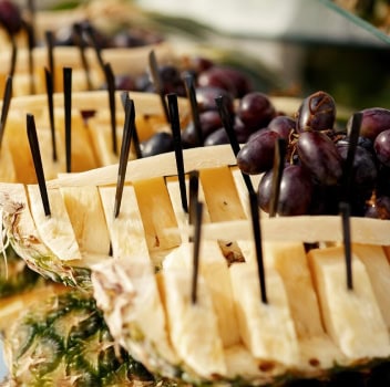 A buffet table displaying an assortment of fresh fruits and various cheeses arranged attractively.