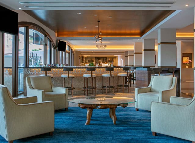 Hotel lobby featuring a bar area with seating and stylish chairs arranged for guests to relax and socialize.