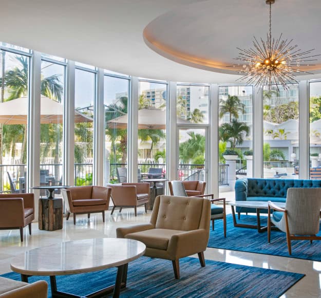 Hotel lobby featuring large windows, comfortable chairs, and a welcoming atmosphere for guests.