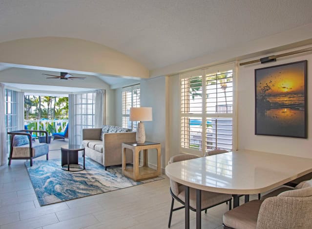 A cozy living room featuring a dining table surrounded by chairs, creating a welcoming atmosphere for gatherings.