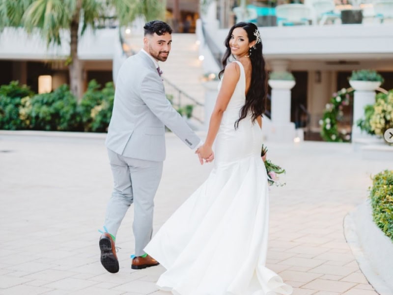 A wedding photographer skillfully documenting a couple's joyful celebration against a vibrant backdrop.