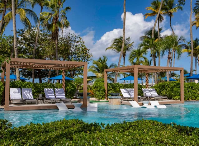 The pool at the Royal Caribbean Resort in Puerto Rico, featuring clear blue water and surrounded by tropical landscaping.