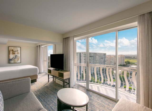 A hotel room featuring a large window with a stunning view of the ocean.