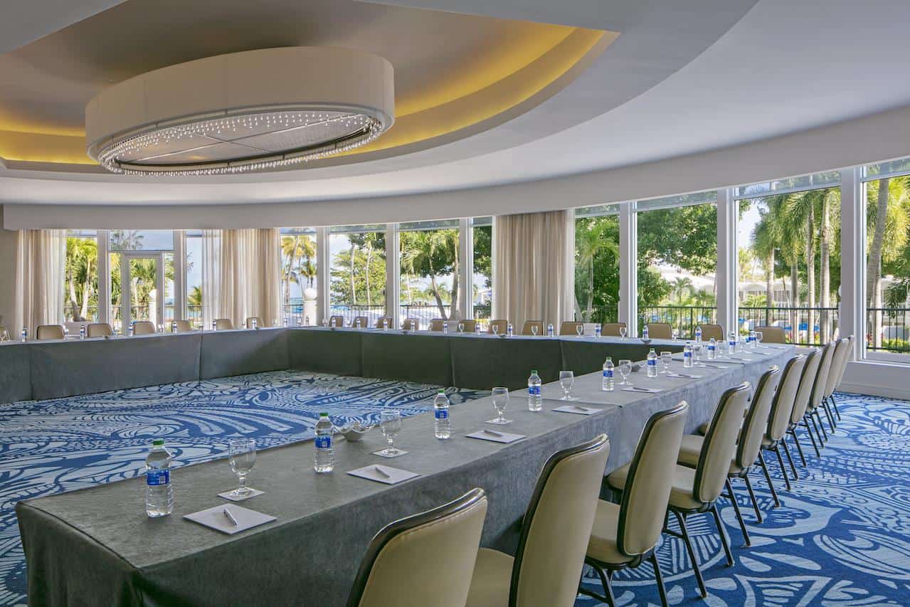 A spacious conference room featuring blue carpet and chairs arranged for a meeting.