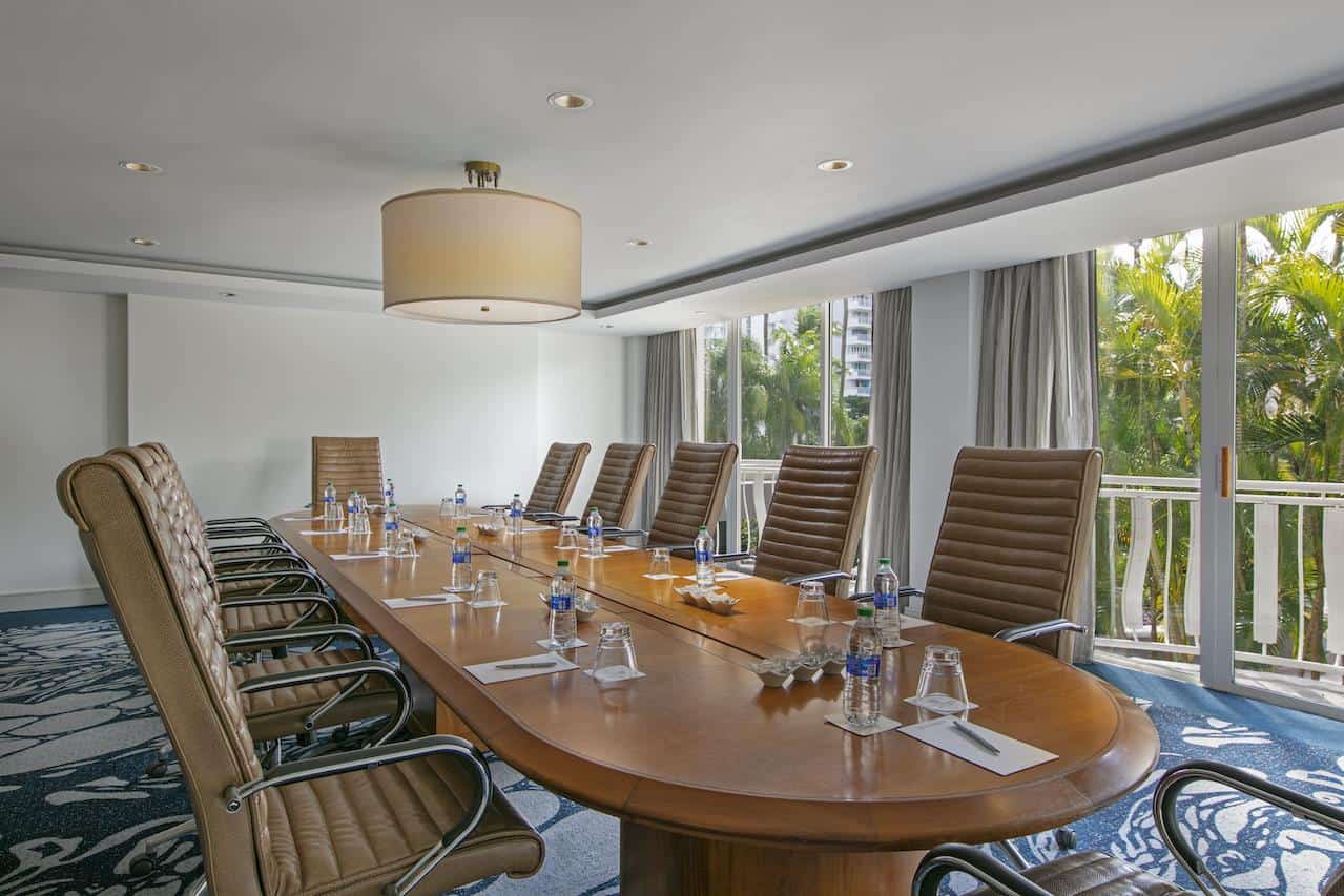 A conference room featuring a long table surrounded by several chairs, designed for meetings and discussions.