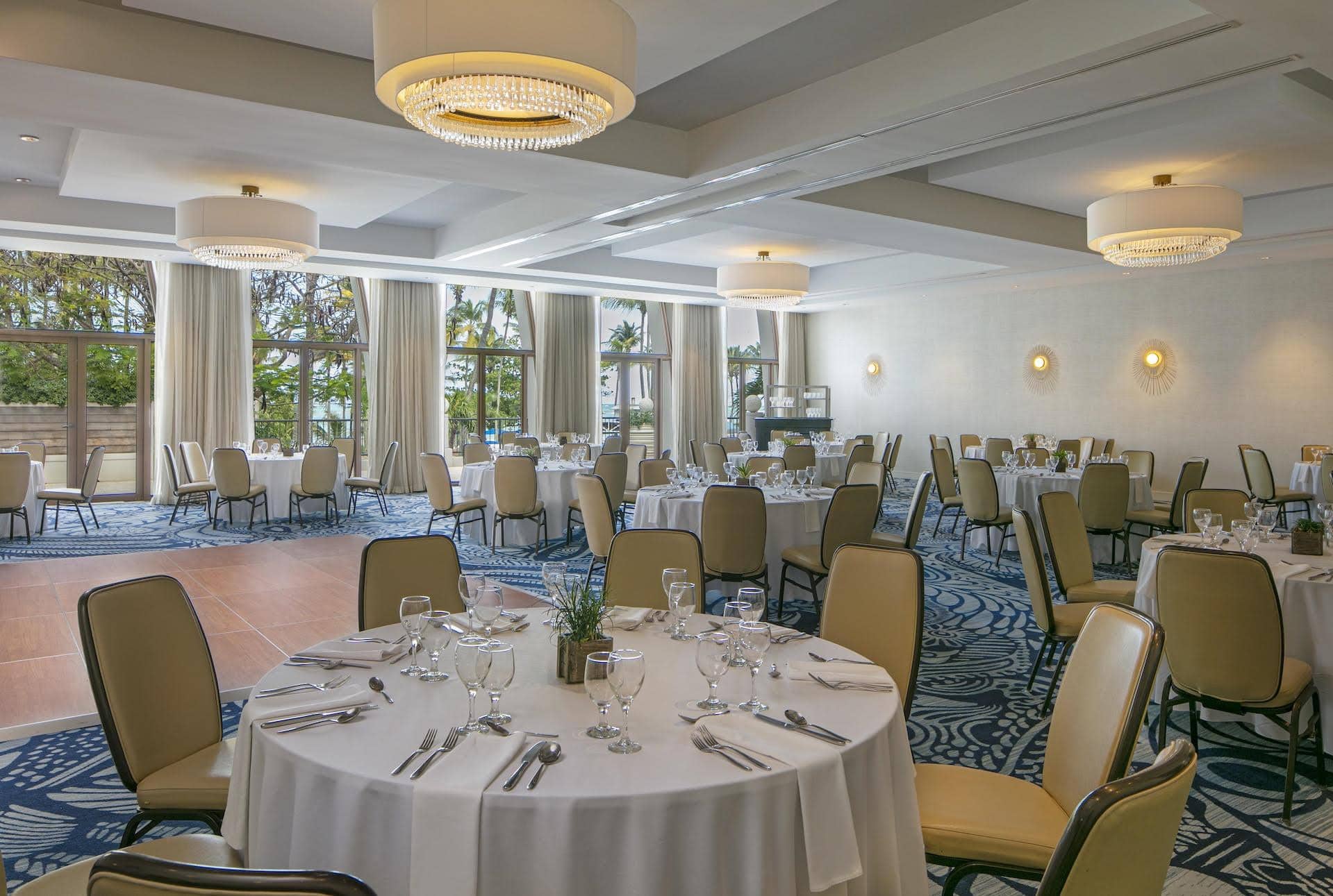 A beautifully arranged banquet room with tables and chairs set for a wedding celebration.