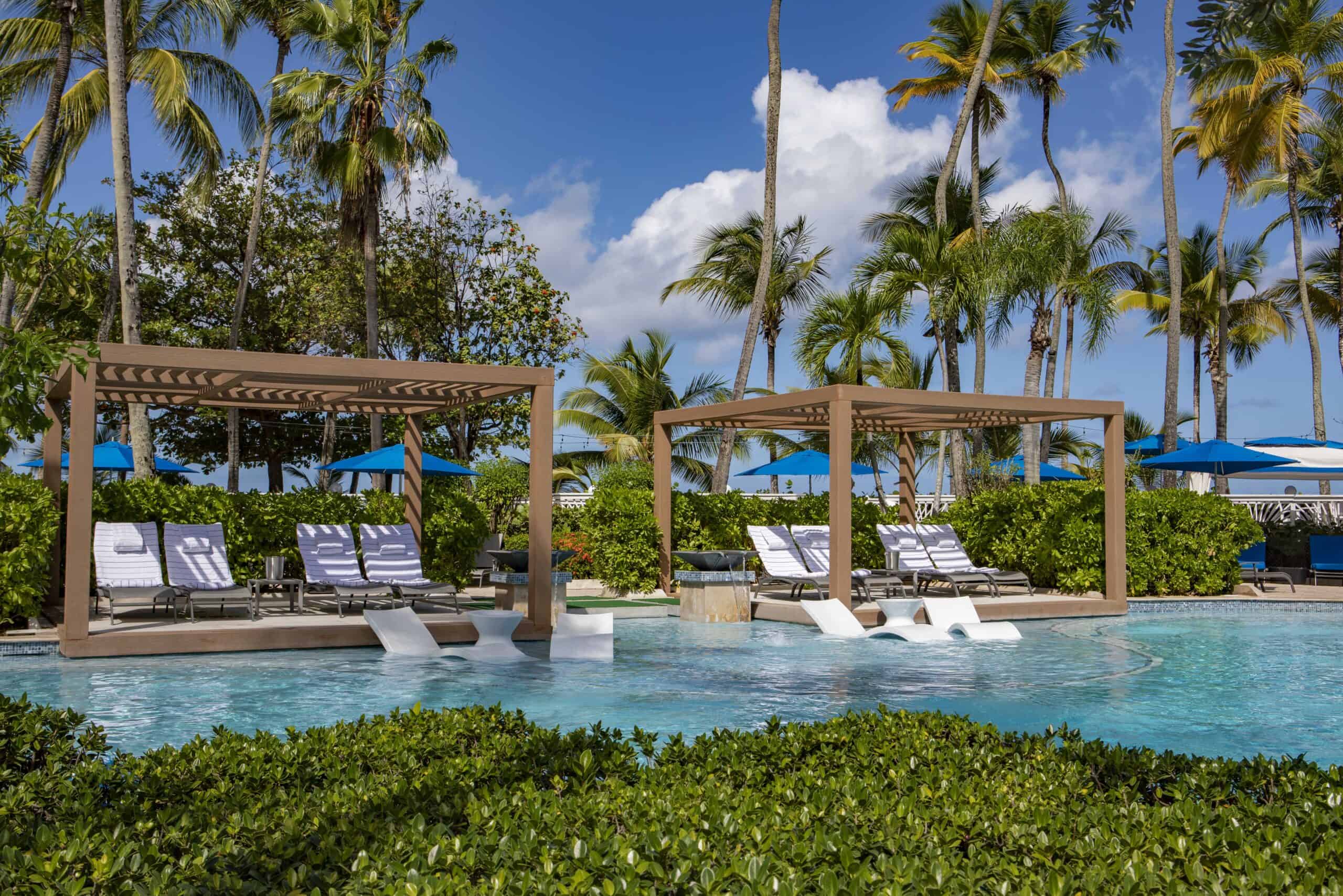 The pool at the Royal Caribbean Resort in Puerto Rico, featuring clear blue water and surrounded by tropical landscaping.