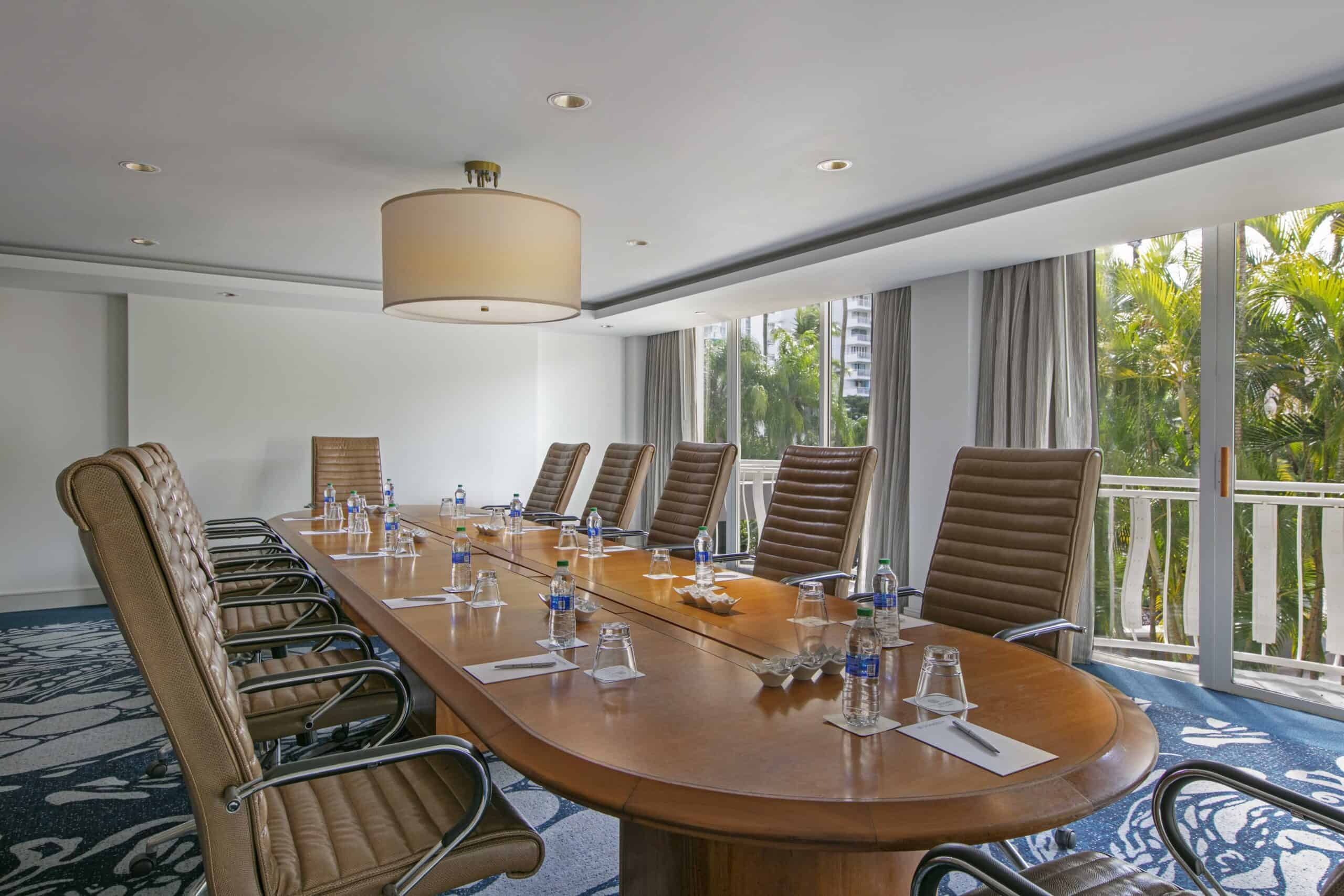 A conference room featuring a large table surrounded by several chairs, designed for meetings and discussions.