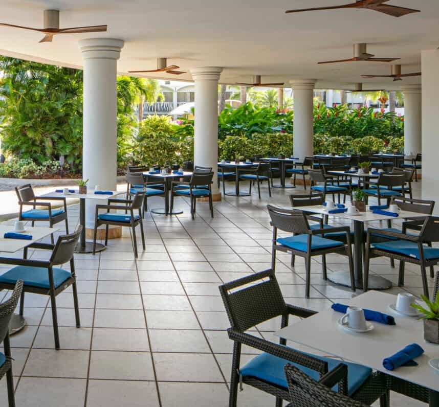 A restaurant patio featuring several tables and chairs arranged for outdoor dining.