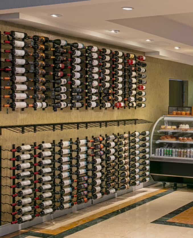 A wooden wine rack filled with various bottles of wine, showcasing a range of colors and labels.