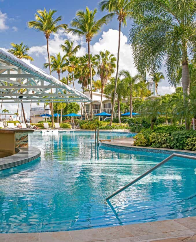 The pool at the Royal Caribbean resort's beach club in St. Lucia, surrounded by palm trees and lounge chairs.
