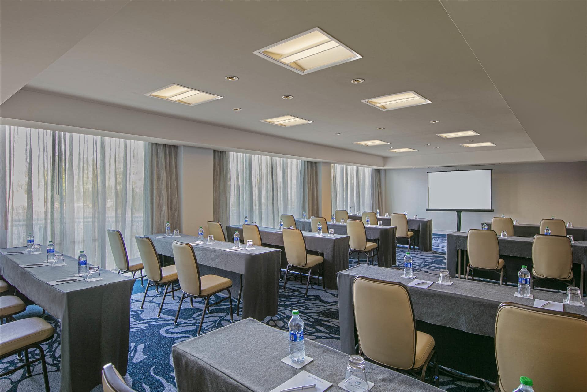 A conference room featuring several tables and chairs arranged for a meeting or presentation.