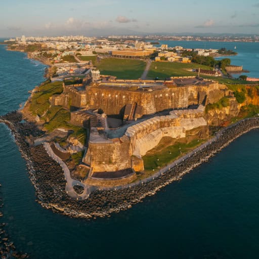 Aerial view of San Juan, Puerto Rico, showcasing the historic fort surrounded by the ocean and cityscape.