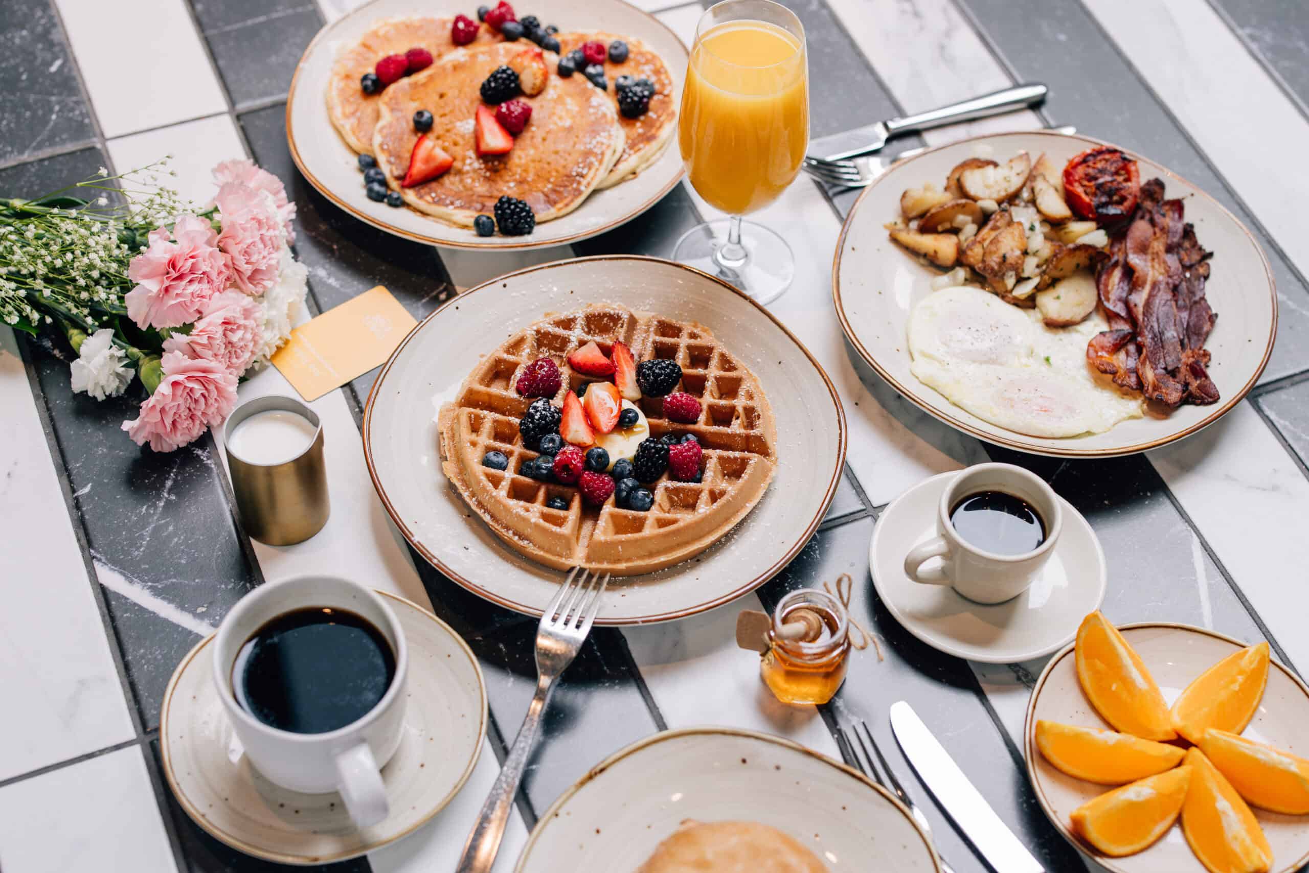 A beautifully arranged breakfast spread at the hotel bar, featuring fruits, pastries, and beverages.