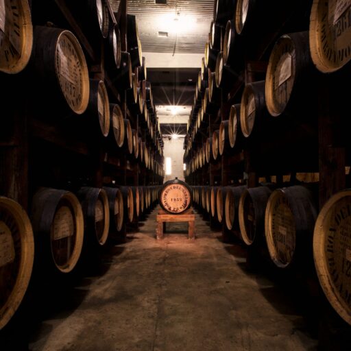 A spacious room filled with numerous whiskey barrels stacked neatly along the walls.