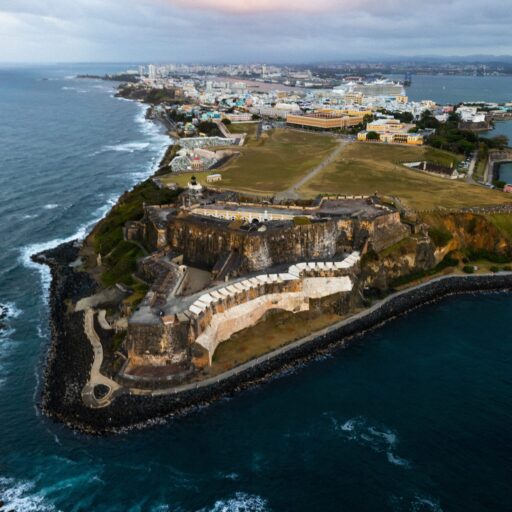A scenic view of San Jose, Puerto Rico, showcasing vibrant buildings and lush greenery under a clear blue sky.