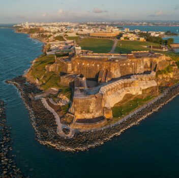 Aerial view of San Juan, Puerto Rico, showcasing the historic fort surrounded by the ocean and cityscape.