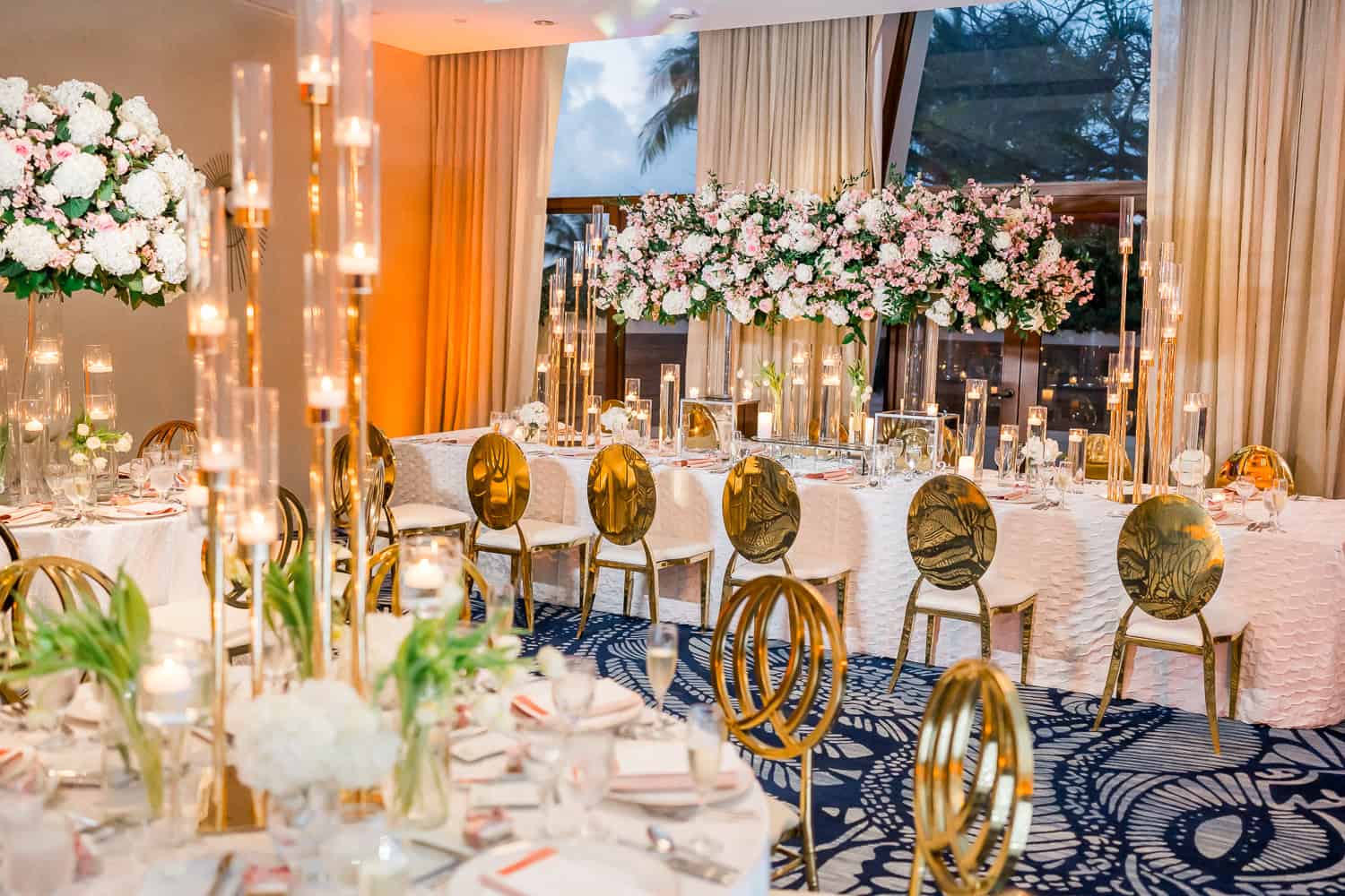 A beautifully arranged wedding reception featuring elegant gold and white decor, creating a romantic atmosphere.