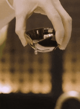 A person holding a small bowl filled with liquid in their hand, showcasing the bowl's contents and their grip.